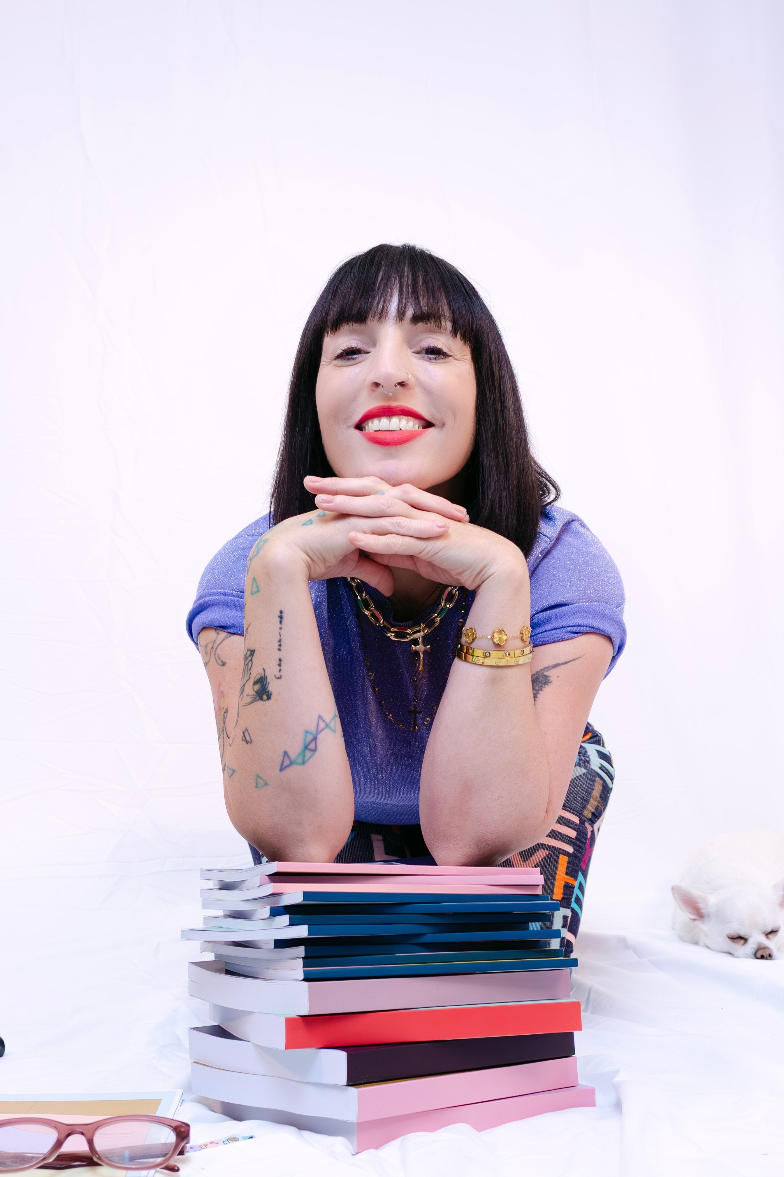 Woman sitting in a studio with books and stationery items