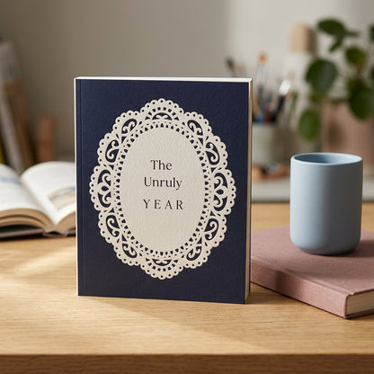 Book titled 'The Unruly Year' on a wooden surface with a cup and books in the background.